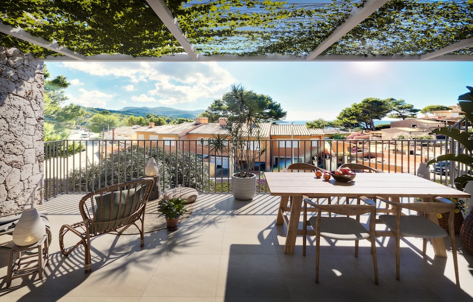 Terraza soleada con mesa de madera, silla de mimbre y pérgola con vides con vistas al paisaje mediterráneo.