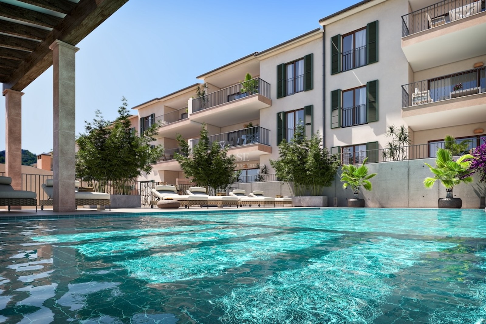 Sparkling turquoise swimming pool with lounge chairs in front of a multi-story Mediterranean apartment building.
