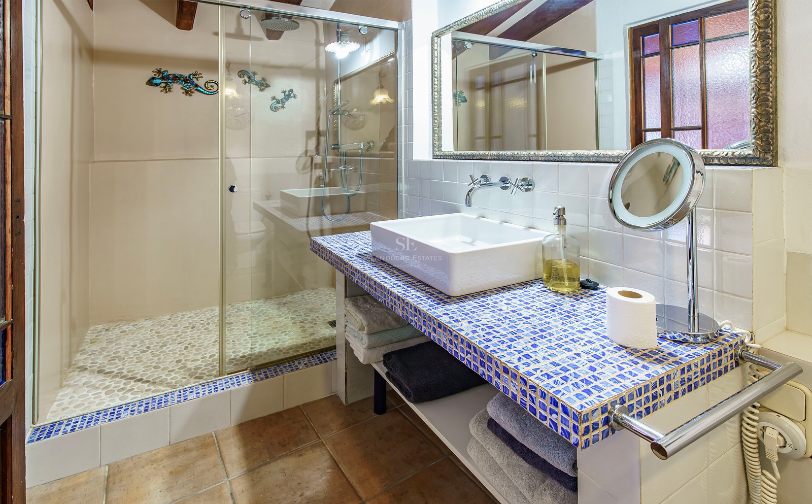 Modernes Badezimmer mit begehbarer Dusche mit Kieselboden und blauem Mosaik-Waschtisch.