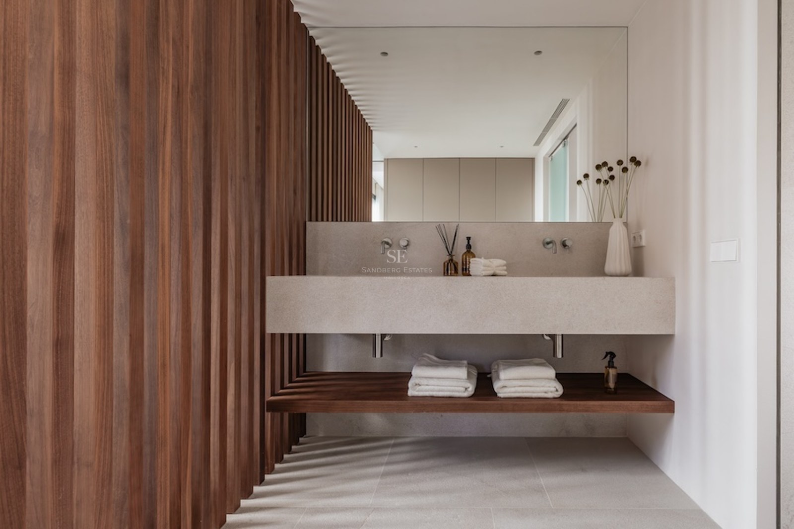 Modernes Badezimmer mit schwebendem Doppelwaschtisch aus Stein, großem Spiegel und dunkler Holzlamellenwand.
