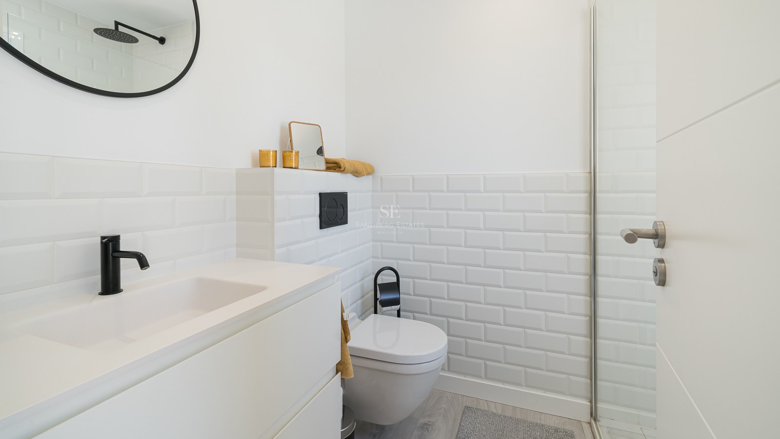 Modern white bathroom featuring subway tiles, black fixtures, and a sleek minimalist vanity.