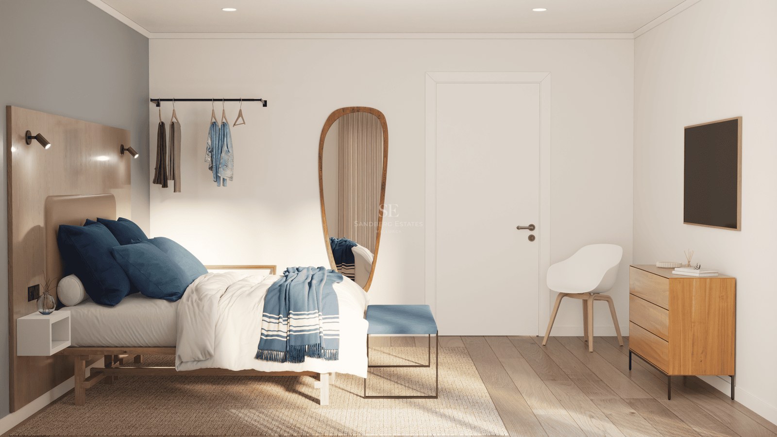 Bright bedroom with a wooden bed, blue linens, an organic-shaped mirror, and light wood furniture.