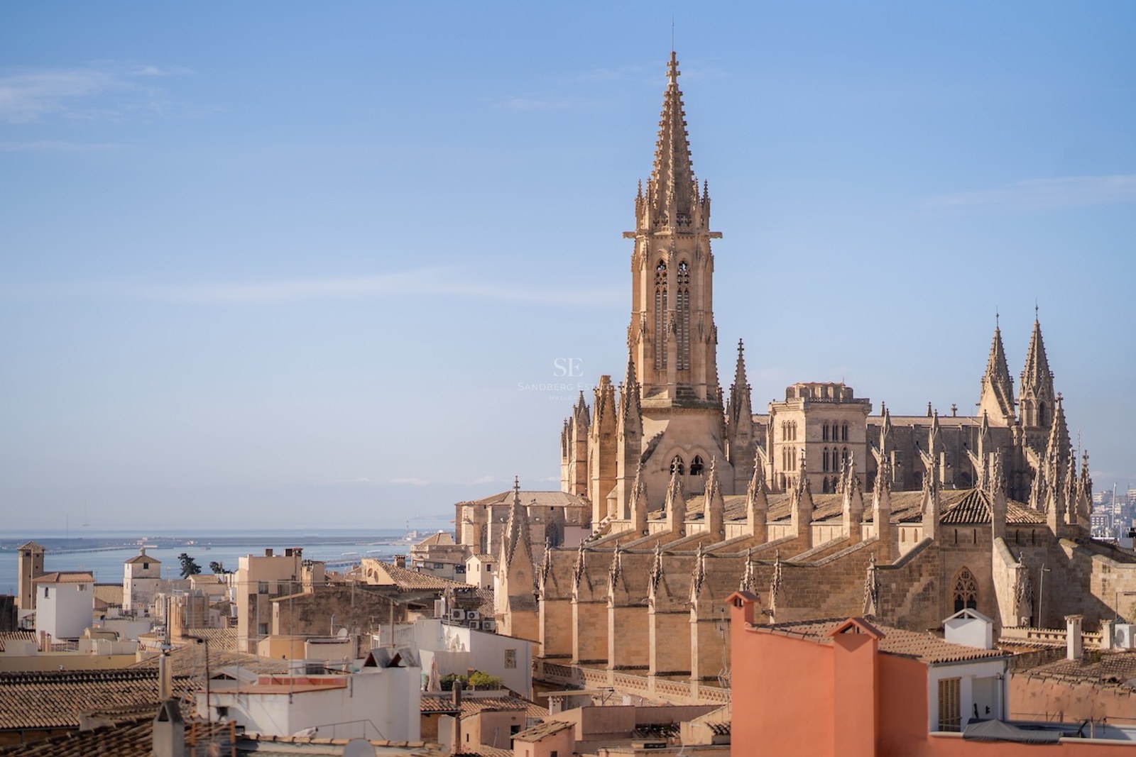 Catedral de Santa María de Palma con vistas a la ciudad y al mar Mediterráneo bajo un cielo despejado.