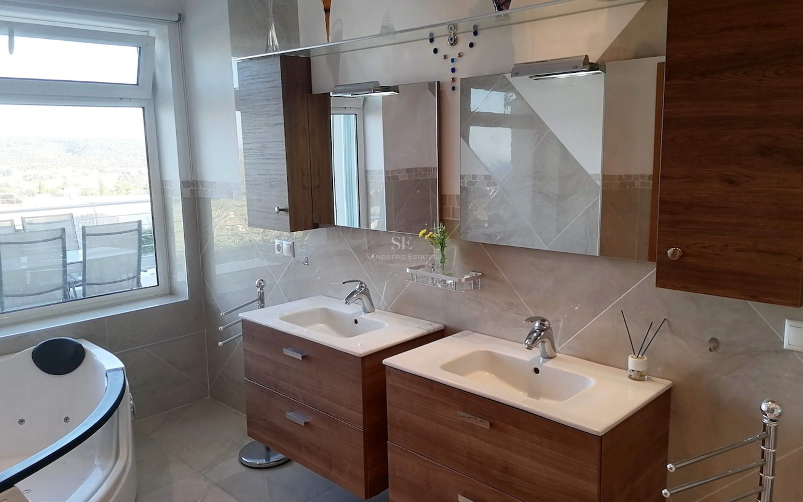 Modern double vanity with wood cabinets, chrome fixtures, and a whirlpool tub next to a large window.