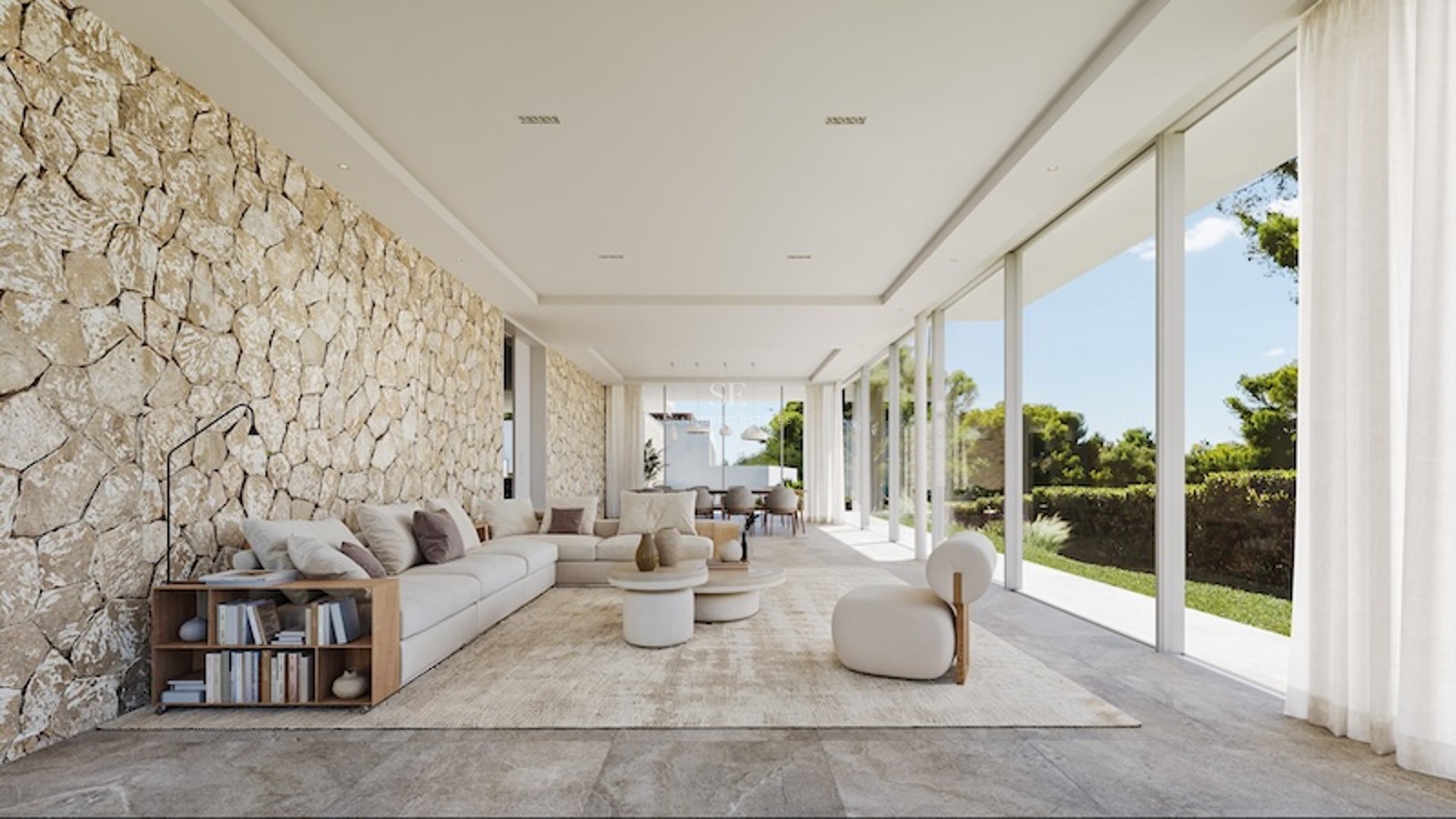Salon lumineux avec baies vitrées toute hauteur, mur en pierre apparente et mobilier moderne de couleur crème.