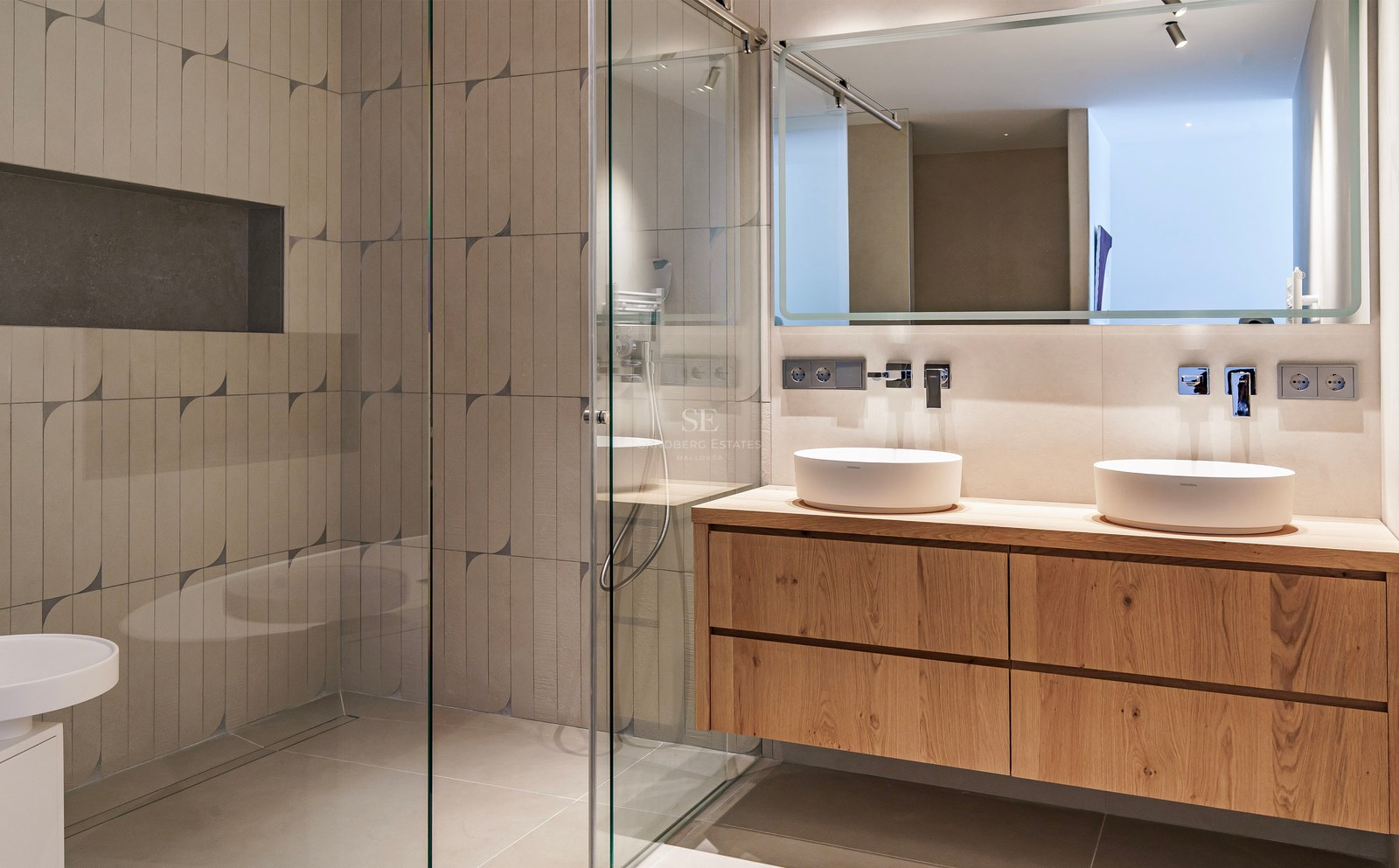 Salle de bains contemporaine avec meuble en bois suspendu, deux vasques blanches et douche à l'italienne.
