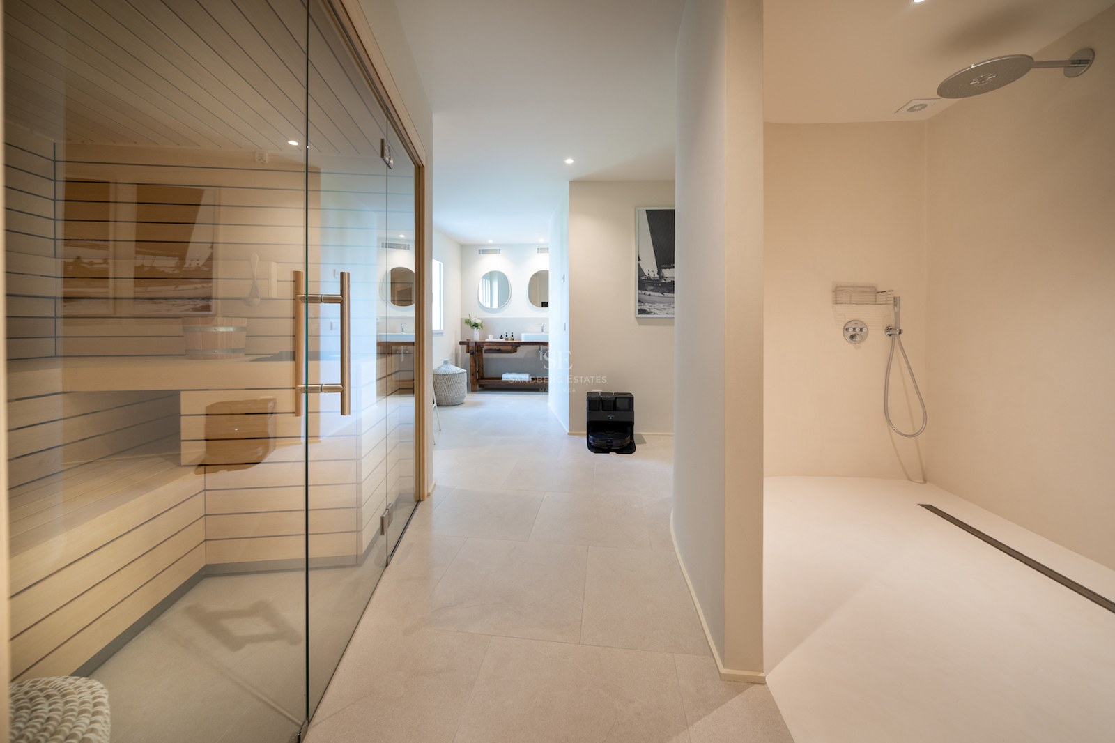 Espace spa intérieur comprenant un sauna vitré, une douche à l'italienne et des sols en pierre claire.