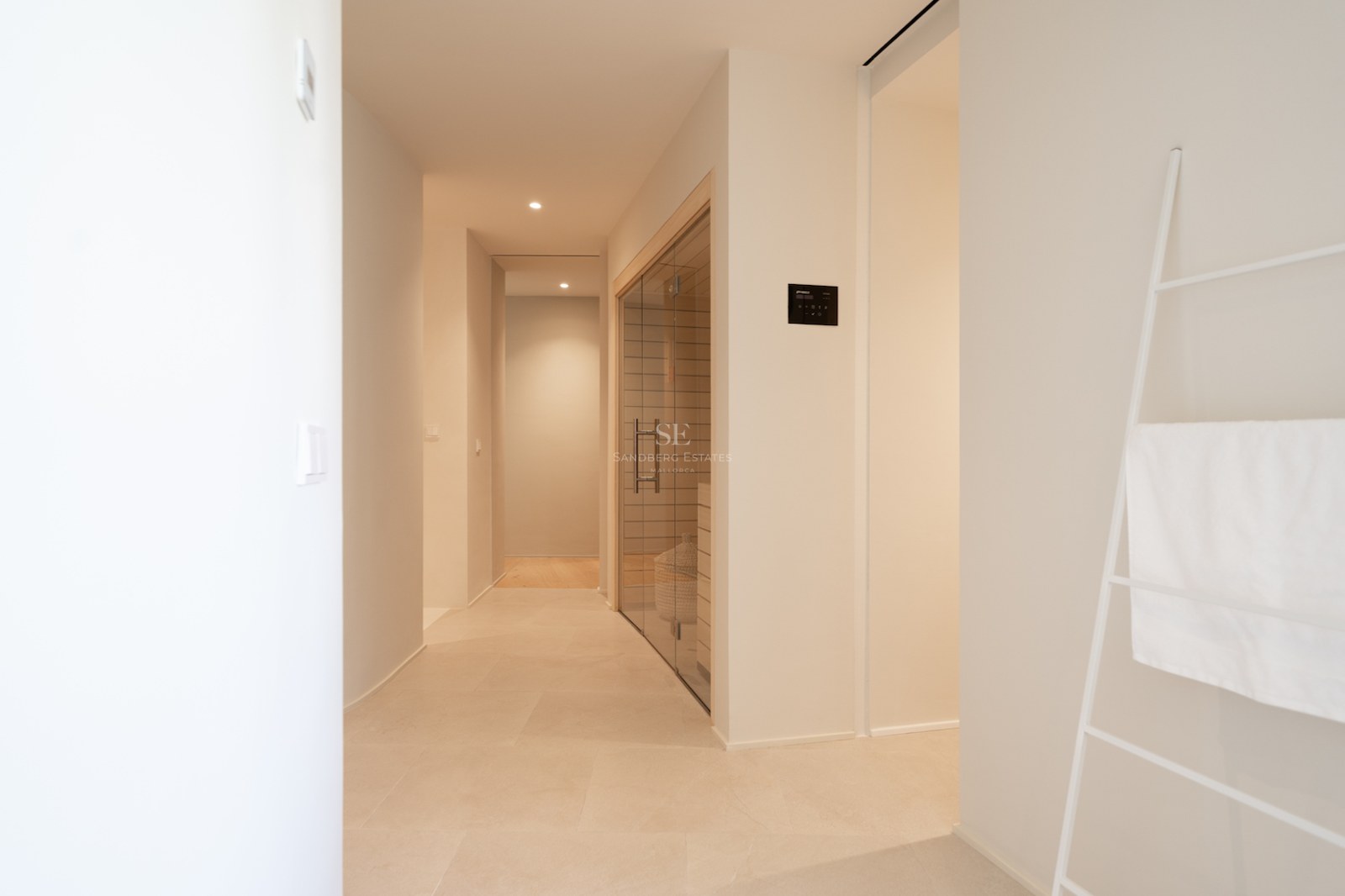 Couloir blanc minimaliste avec sauna privé doté de parois en verre et d'un intérieur en bois clair.