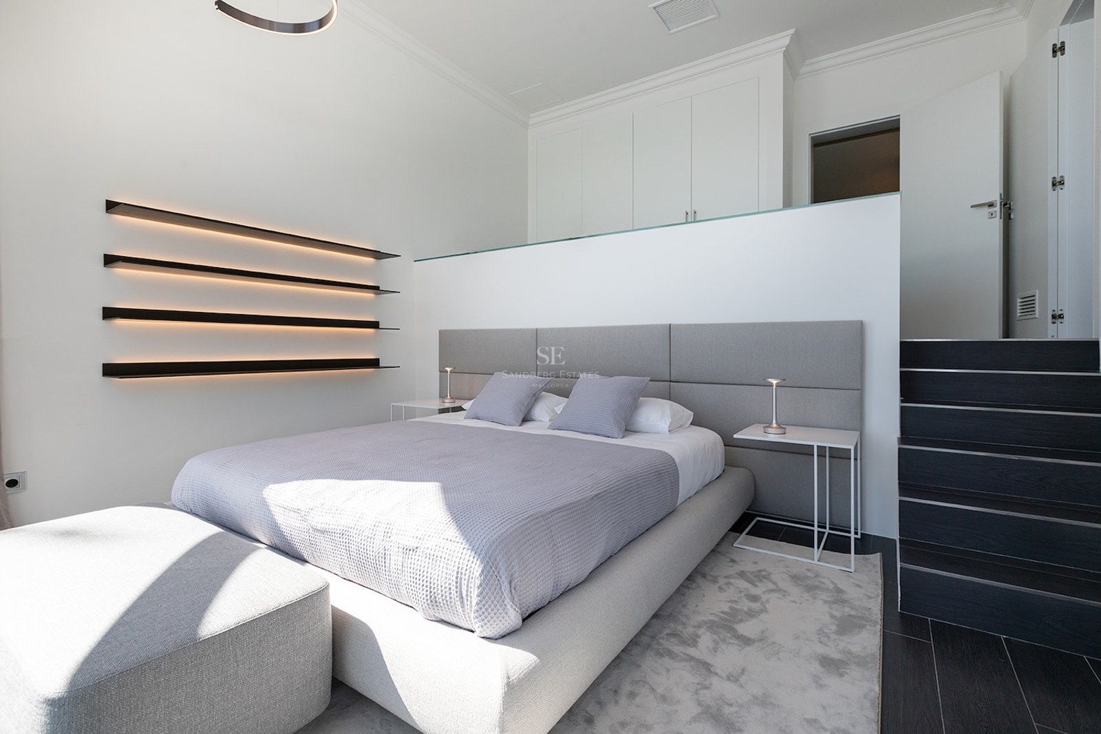 Chambre moderne avec lit gris, étagères LED intégrées et design minimaliste blanc.