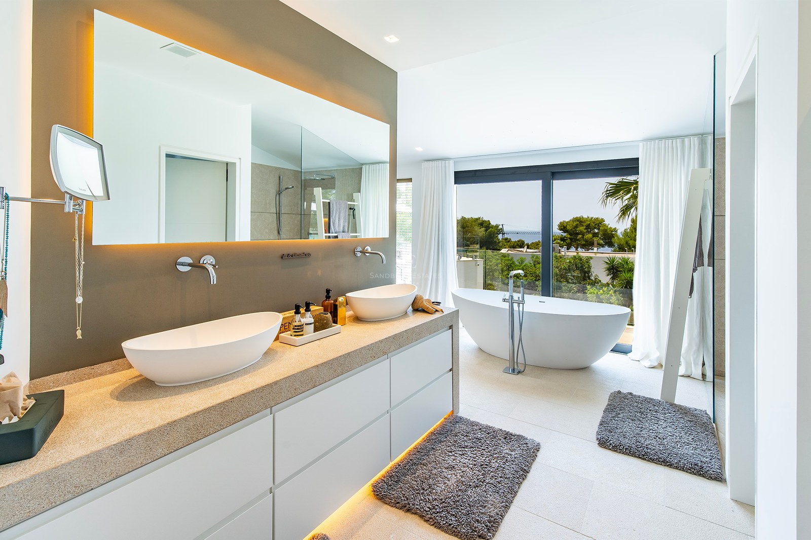 Exteriörvy av en modern villa med reflekterande pool, stora fönster och minimalistisk design i neutrala toner.