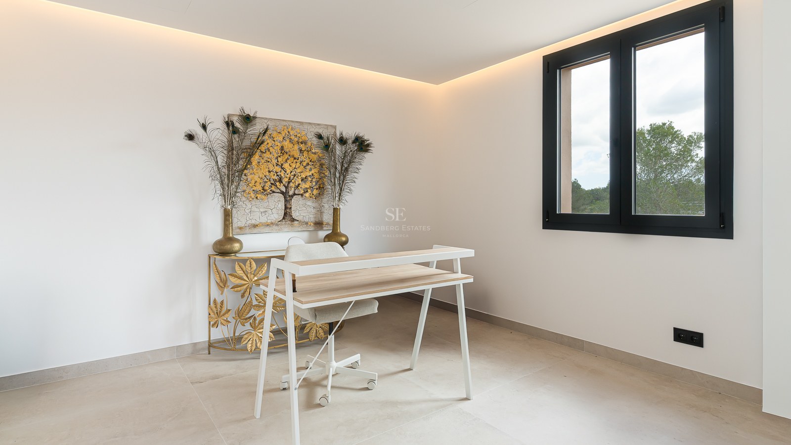 A modern study area featuring a white desk, gold artwork, and warm LED cove lighting in a white room.
