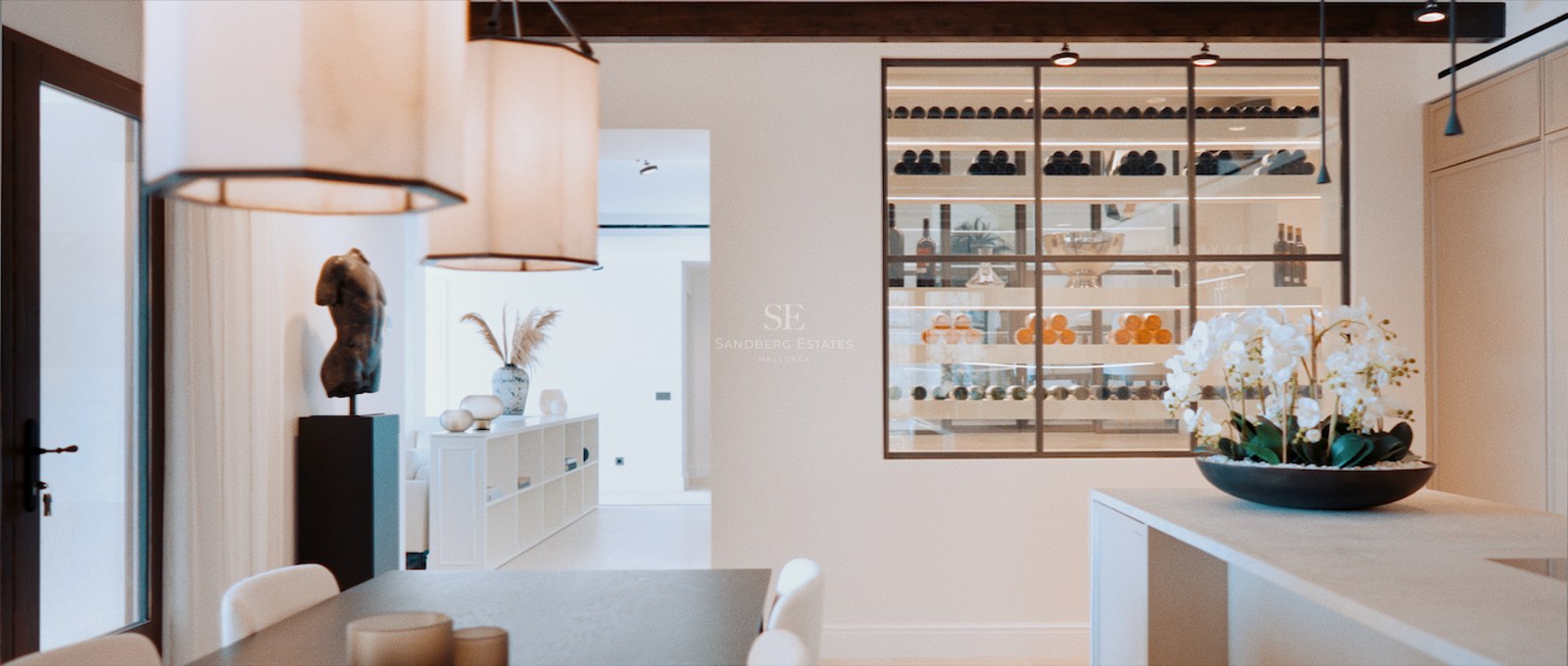 Modern dining area featuring a glass-enclosed wine display, wooden beams, and designer pendant lights.