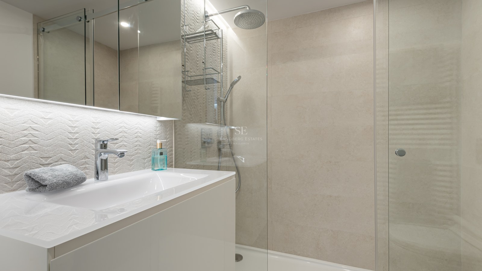 Contemporary bathroom featuring a glass walk-in shower, white vanity, and textured cream wall tiles.