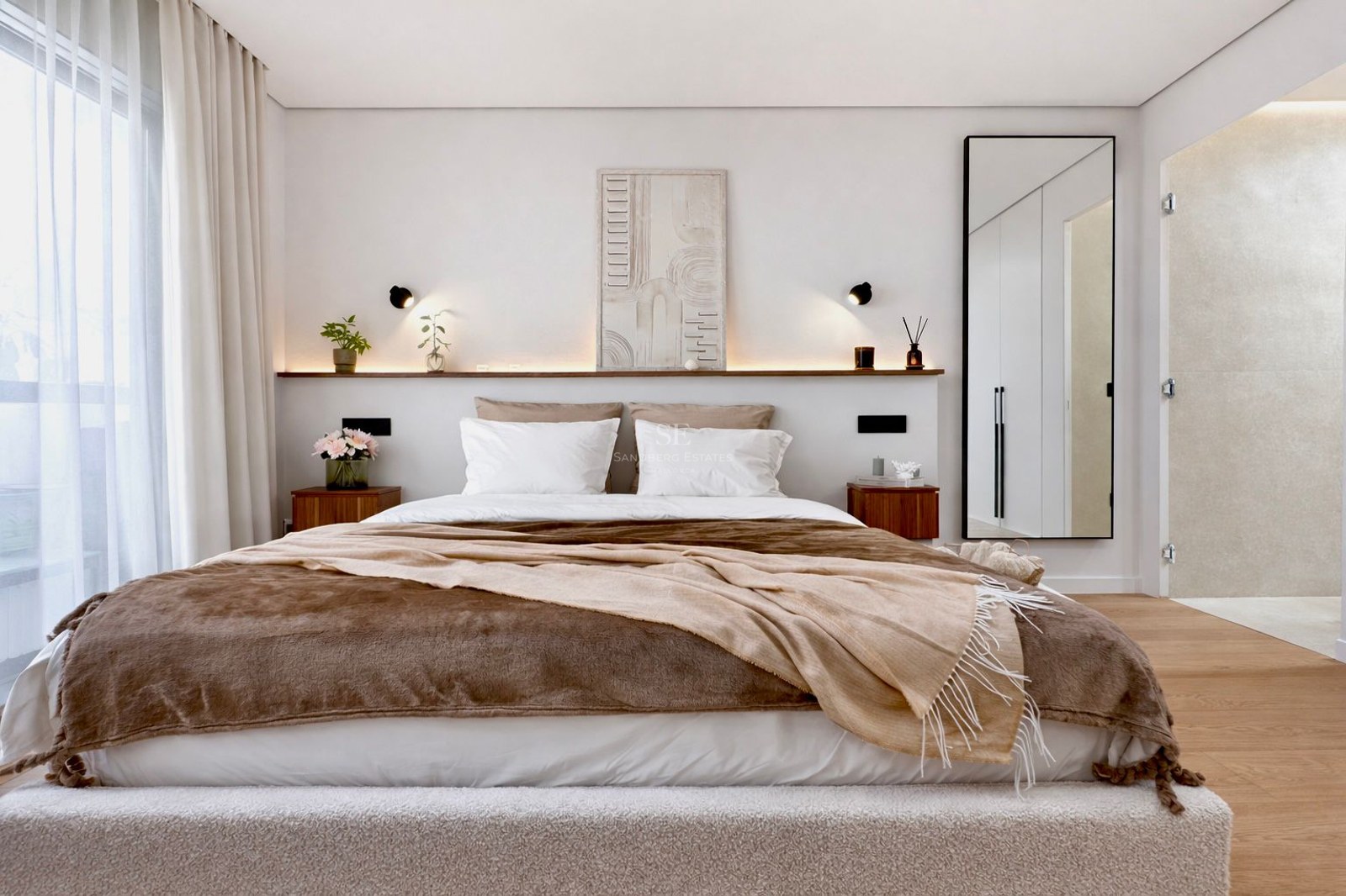 Chambre de maître lumineuse avec grand lit, parure de lit marron, tables de nuit en bois et éclairage LED intégré.