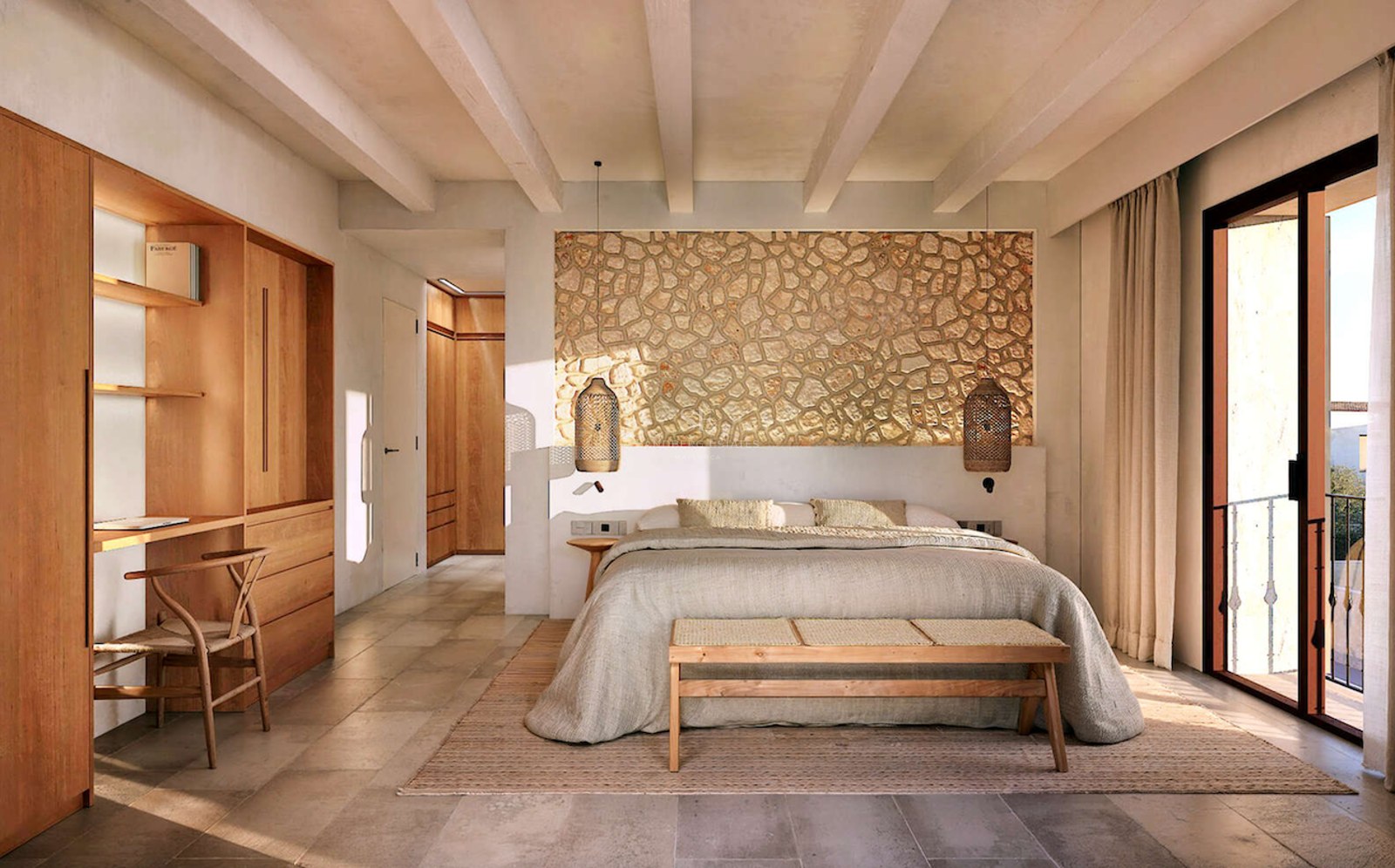 Chambre de luxe avec mur en pierre, poutres apparentes, bureau intégré en bois et porte-fenêtre.