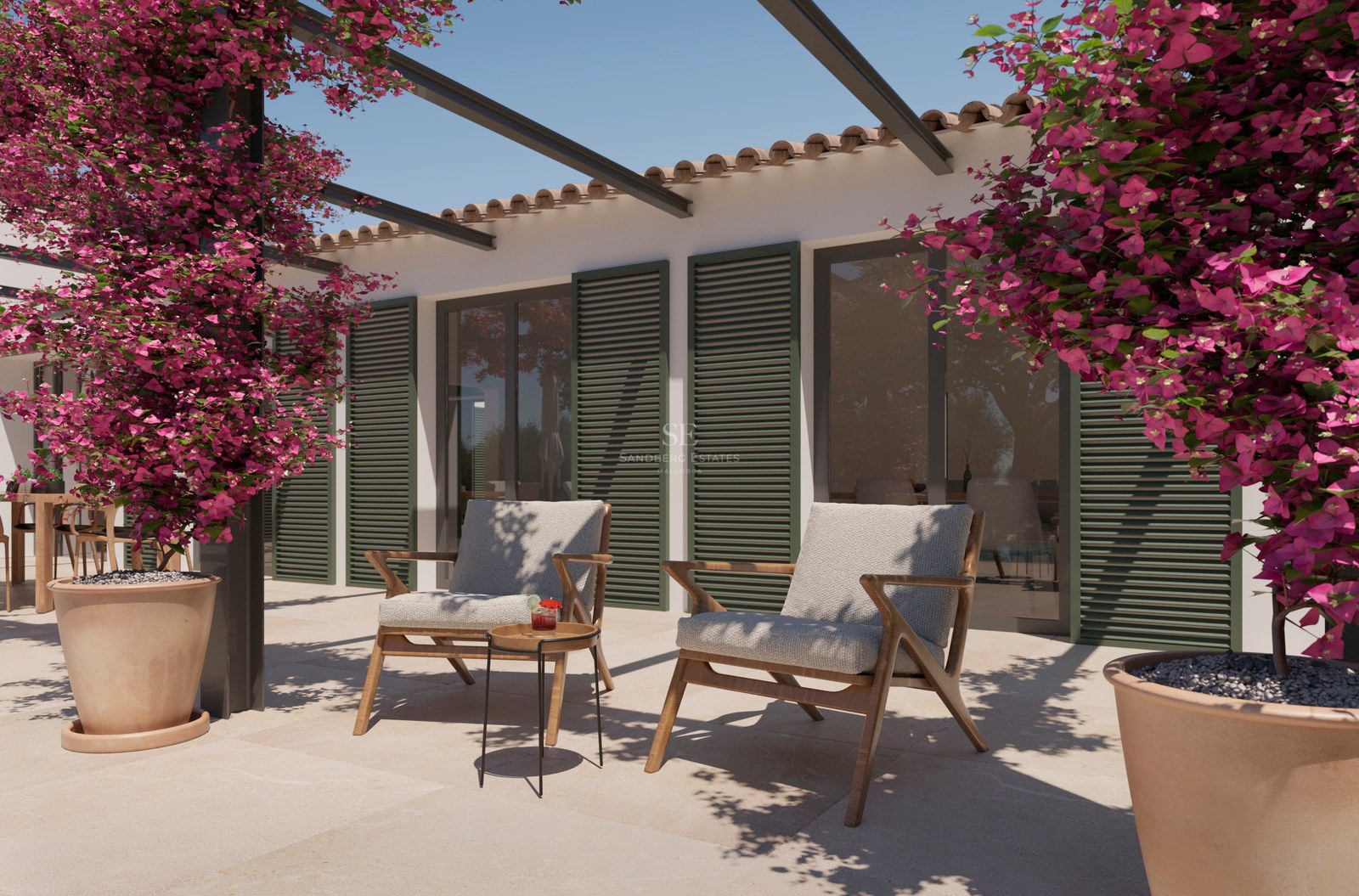 Steinterrasse mit zwei Holzsitzsesseln, grünen Fensterläden und leuchtend rosa Bougainvillea unter blauem Himmel.