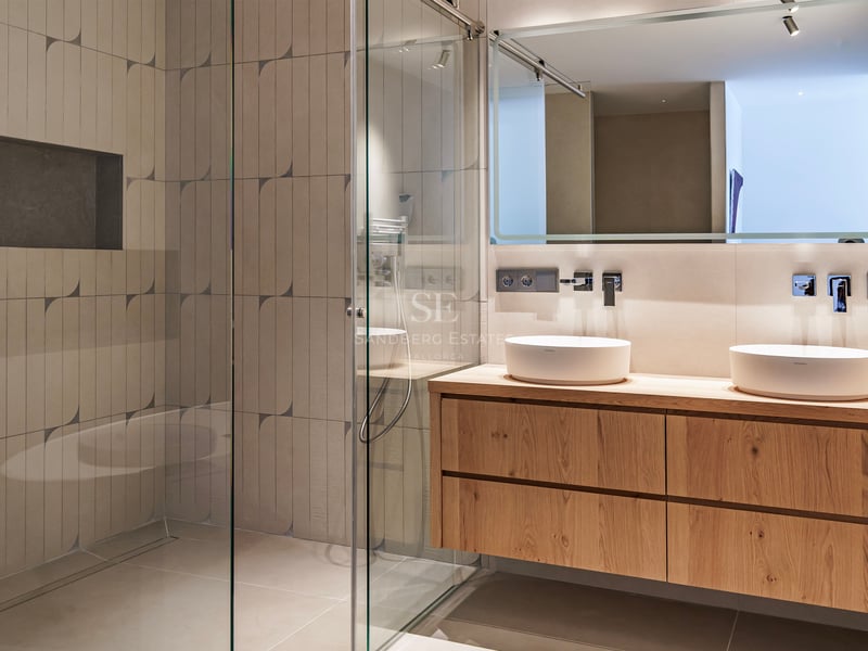Salle de bains contemporaine avec meuble en bois suspendu, deux vasques blanches et douche à l'italienne.