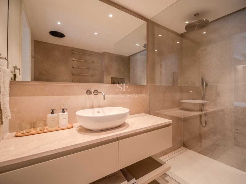 Salle de bain moderne avec vasque à poser, plan de travail en marbre et douche à l'italienne vitrée.