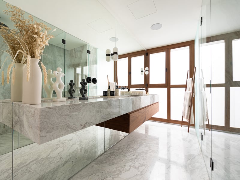 Baño de lujo con lavabo doble de mármol flotante, detalles en madera de nogal y grandes ventanales con marcos de madera.