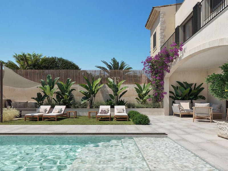 Espace piscine de luxe avec mosaïque turquoise, chaises longues sur pelouse et salon extérieur ombragé sous une arche.