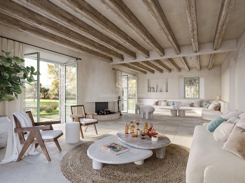 Vaste salon méditerranéen avec poutres en bois, sol en pierre, tables en marbre et vue sur le jardin.