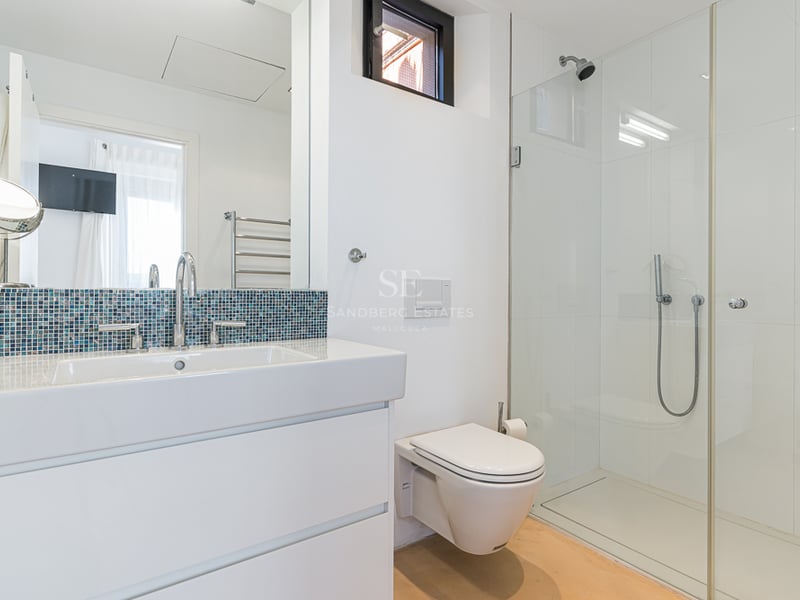 Salle de bain contemporaine avec vanité blanche, crédence en mosaïque bleue et douche à l'italienne.