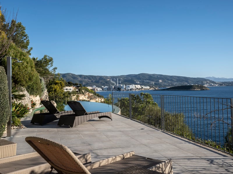 Terrasse de luxe avec bains de soleil, piscine à débordement et vue panoramique sur la Méditerranée.