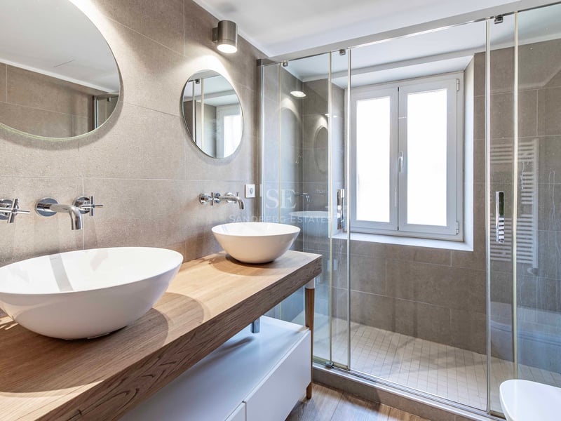 Salle de bains contemporaine avec double vasque en céramique, plan en bois et douche à l'italienne vitrée.