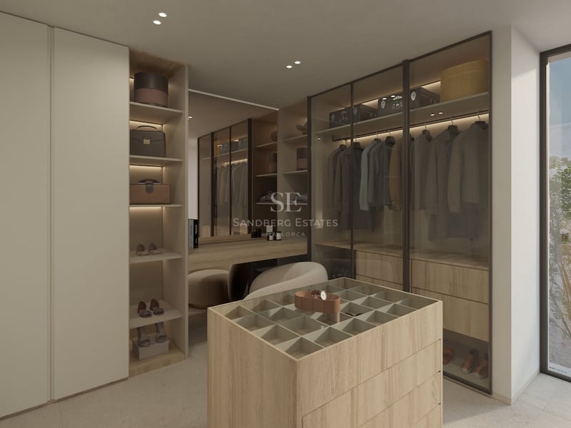 Un dressing minimaliste avec des armoires en bois et en verre, un îlot central et de la lumière naturelle.