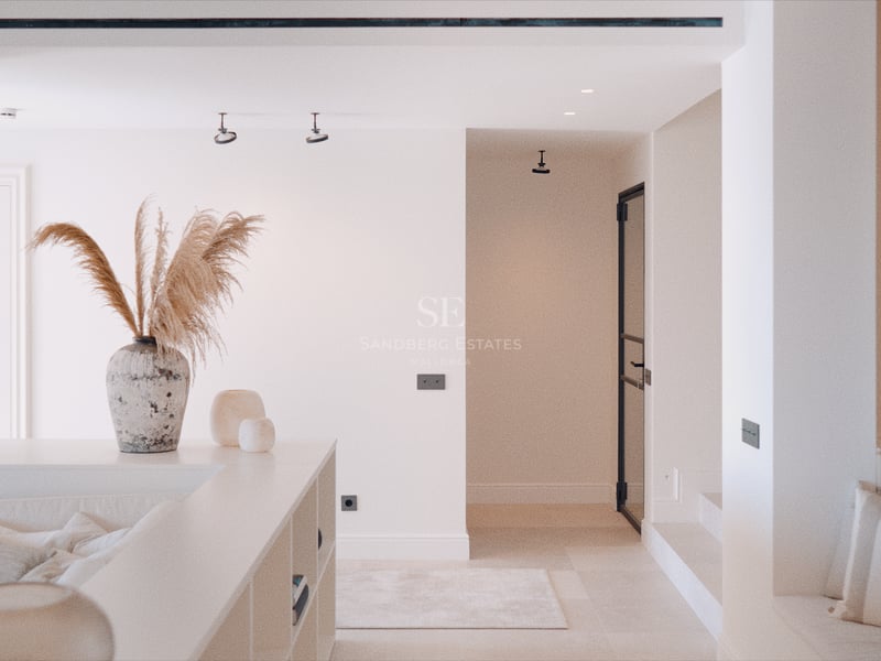 Coin salon encastré avec canapé beige, vase en pierre avec herbe de la pampa et murs blancs épurés.
