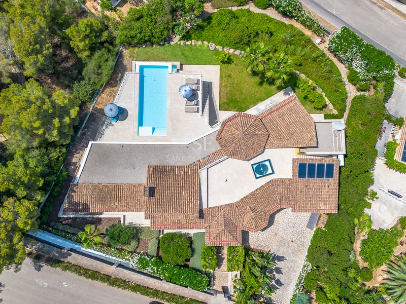 Vue extérieure d'une villa moderne avec piscine à débordement, jardin et vastes terrasses. Design minimaliste avec grandes baies vitrées et architecture élégante.