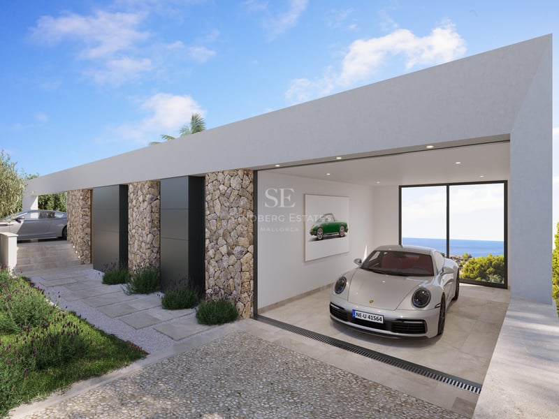 Voiture de sport argentée dans un garage blanc minimaliste avec murs en pierre et baie vitrée donnant sur l'océan.