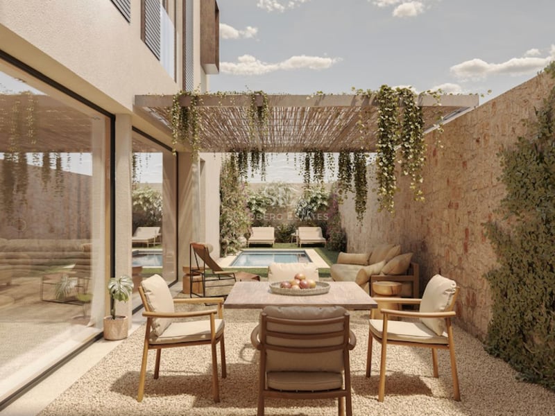 Terrasse moderne avec table à manger, mur en pierre, pergola végétalisée et piscine en arrière-plan.