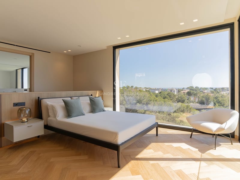 Chambre contemporaine avec parquet en chêne en point de Hongrie et grande baie vitrée donnant sur un paysage verdoyant.