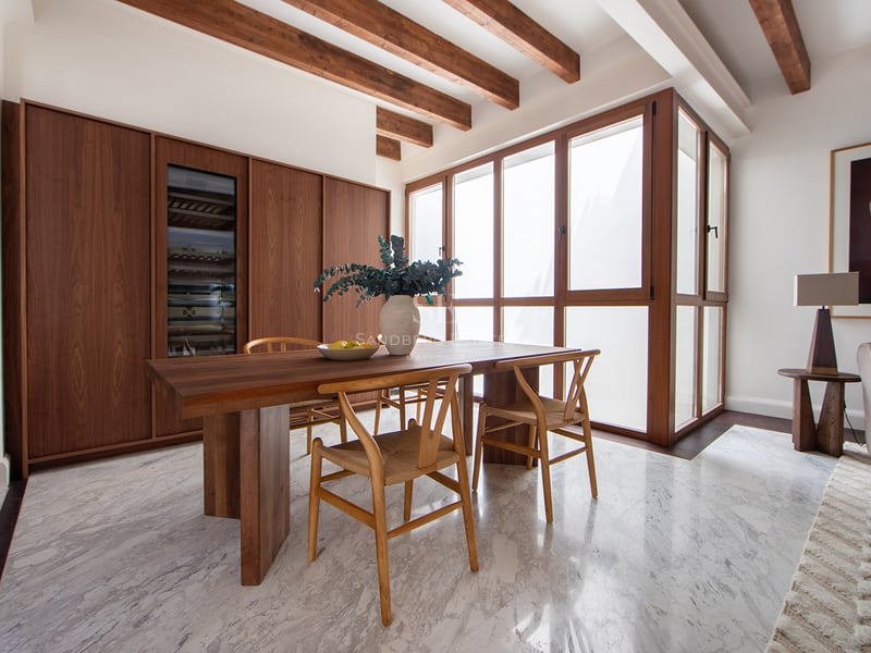 Comedor moderno con suelos de mármol, vigas de madera, mesa de madera maciza y vinoteca integrada en Marbella.