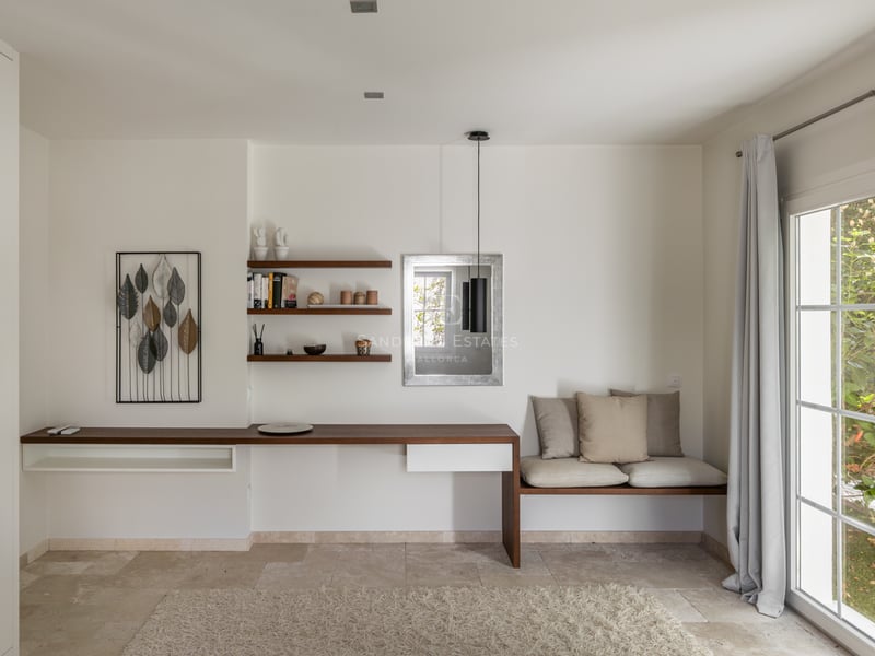 Bureau minimaliste moderne avec bureau flottant en bois, sol en pierre naturelle et banquette intégrée.