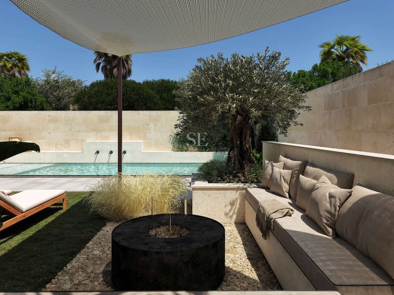 Terrasse de luxe avec banquettes en pierre intégrées, brasero circulaire noir, olivier et piscine.