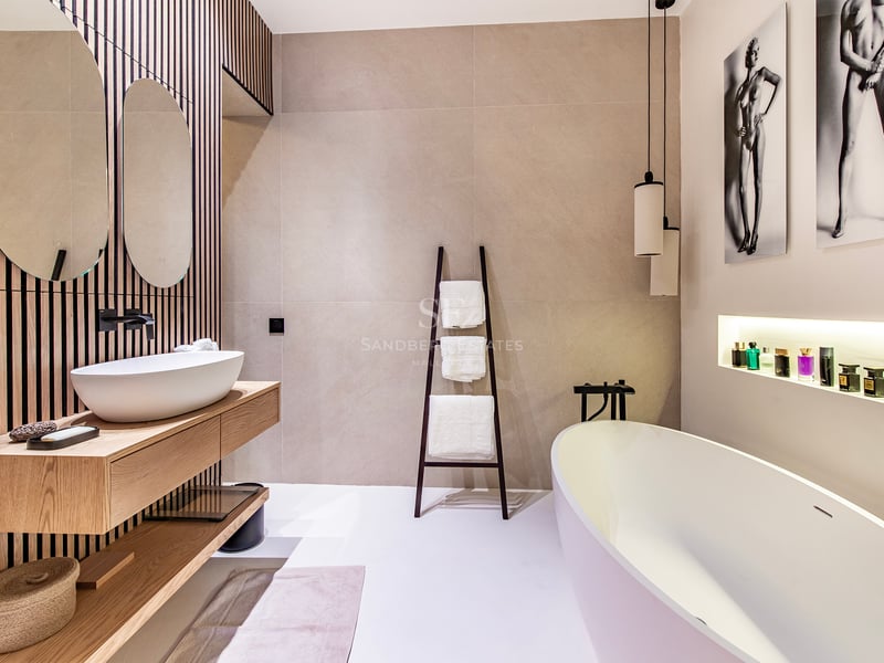 Vue extérieure d'une villa luxueuse avec piscine à débordement, jardin et architecture moderne. Design minimaliste avec grandes baies vitrées.