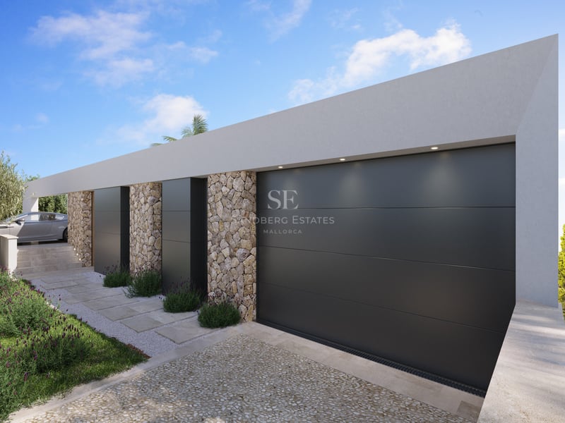 Extérieur de villa contemporaine avec grandes portes de garage anthracite et murs en pierre naturelle apparente.