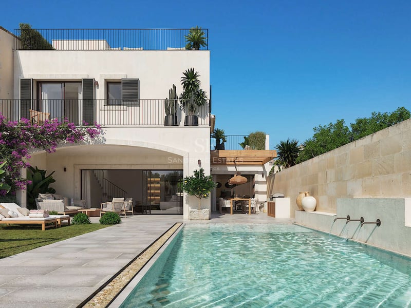 Extérieur de villa de luxe avec piscine turquoise, chaises longues sur gazon et terrasse en pierre naturelle.