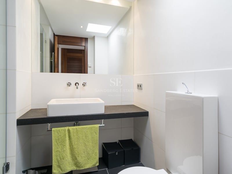 Salle de bains contemporaine avec vasque à poser sur plan en pierre sombre et grand miroir.