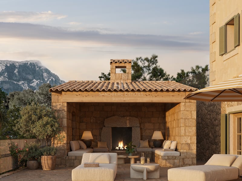 Espace piscine de luxe avec cabane en pierre, cheminée extérieure et vue sur les montagnes au crépuscule.