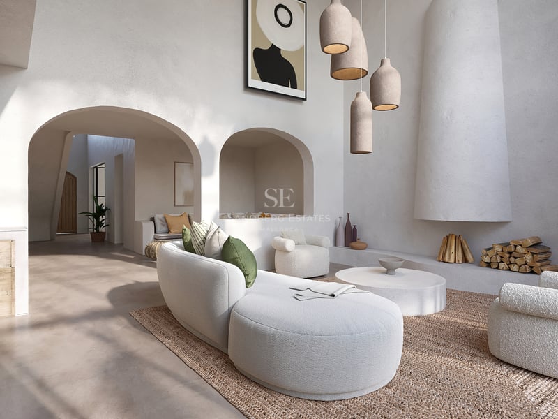 Élégant salon blanc avec canapés incurvés en bouclé, cheminée sculpturale et arches en plâtre texturé.