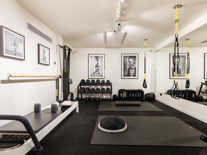 Salle de sport moderne avec Reformer Pilates, TRX, poids libres et sol en caoutchouc professionnel.