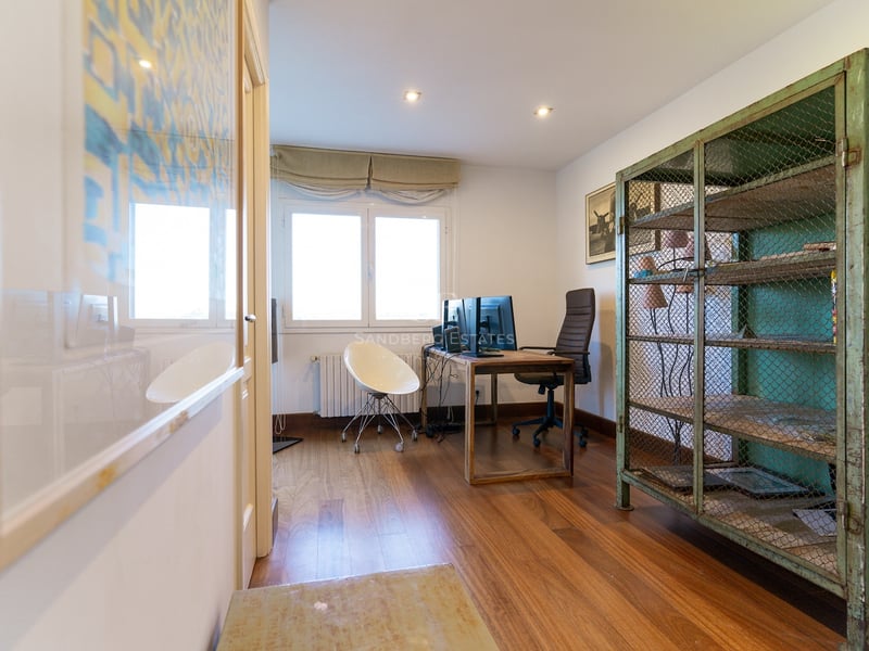 Bureau à domicile avec parquet, bureau à double écran et une armoire grillagée en métal vert vintage.