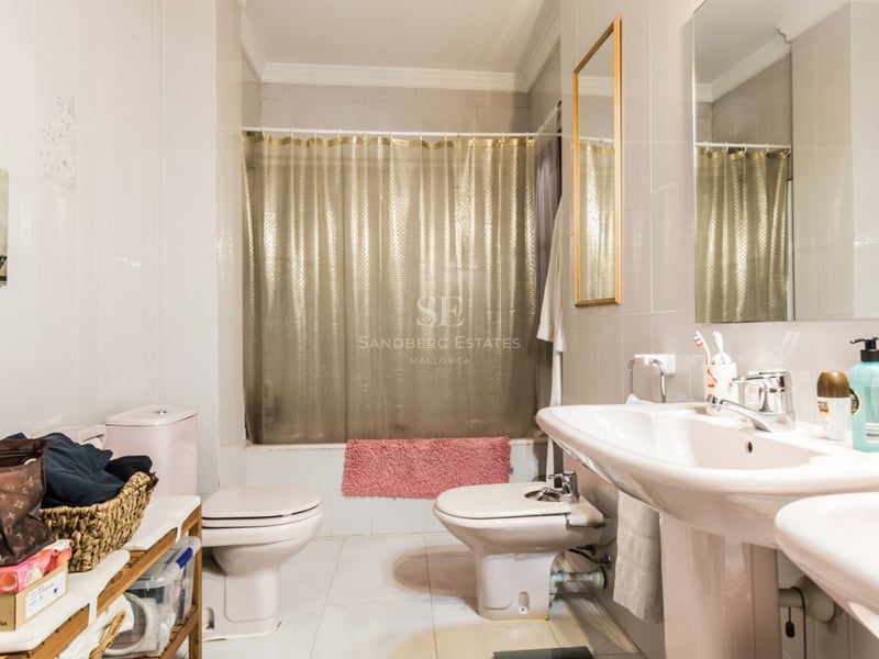 Salle de bain avec double vasque, toilettes, bidet et baignoire avec rideau doré.