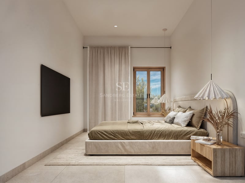 Une chambre minimaliste avec un lit rembourré, une table de chevet en bois, des suspensions et de la lumière naturelle.