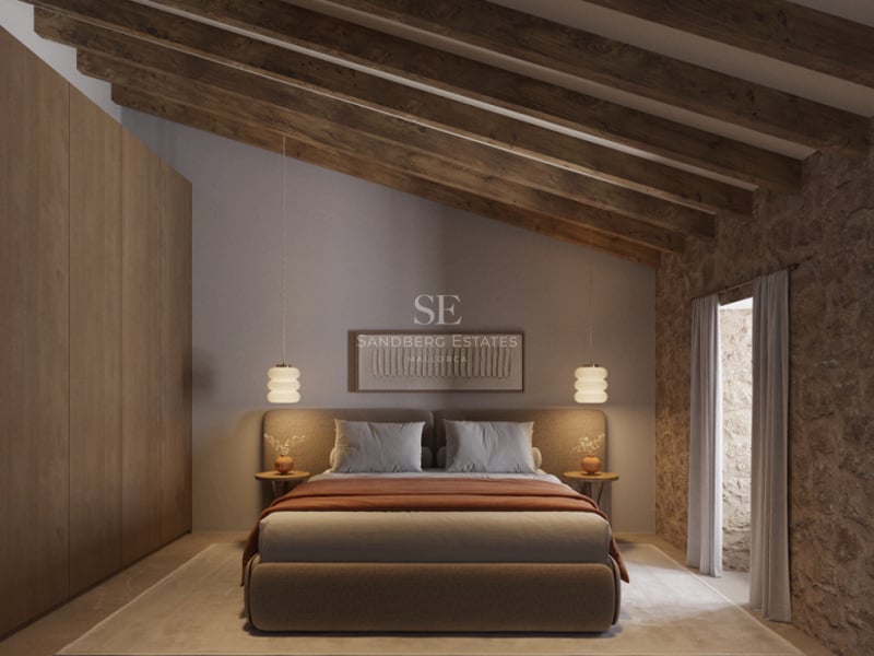Chambre avec plafond en poutres de bois, mur en pierre naturelle et placards intégrés en chêne.