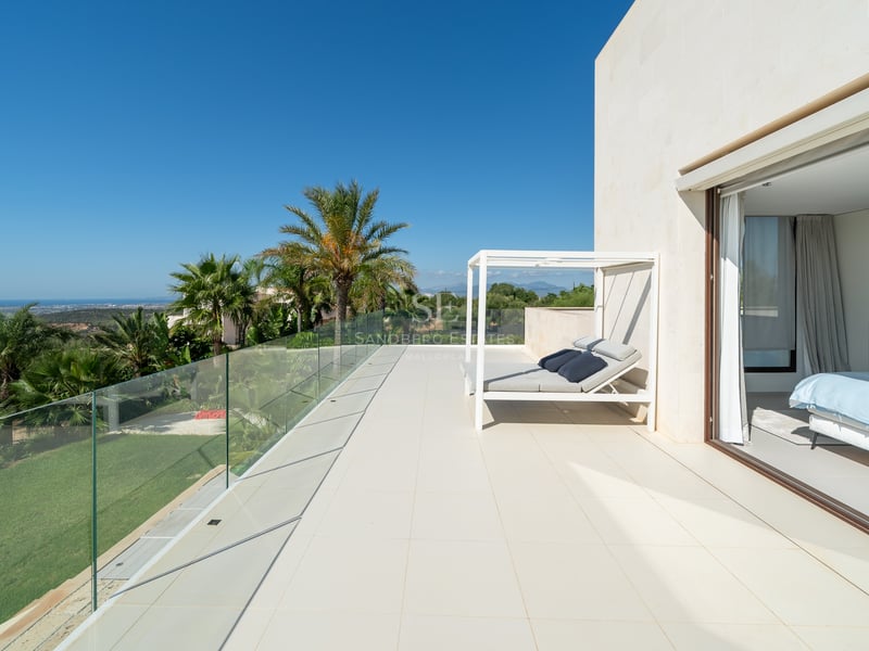 Vue extérieure d'une villa moderne avec piscine, grandes baies vitrées et jardin luxuriant. Design minimaliste et finitions haut de gamme.