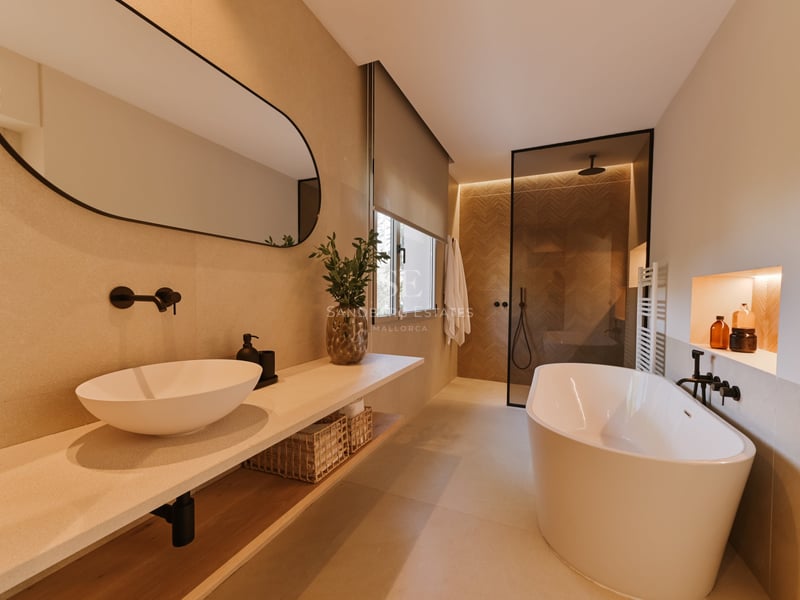 Salle de bain moderne avec baignoire îlot blanche, vasque à poser sur plan en pierre et douche à l'italienne.